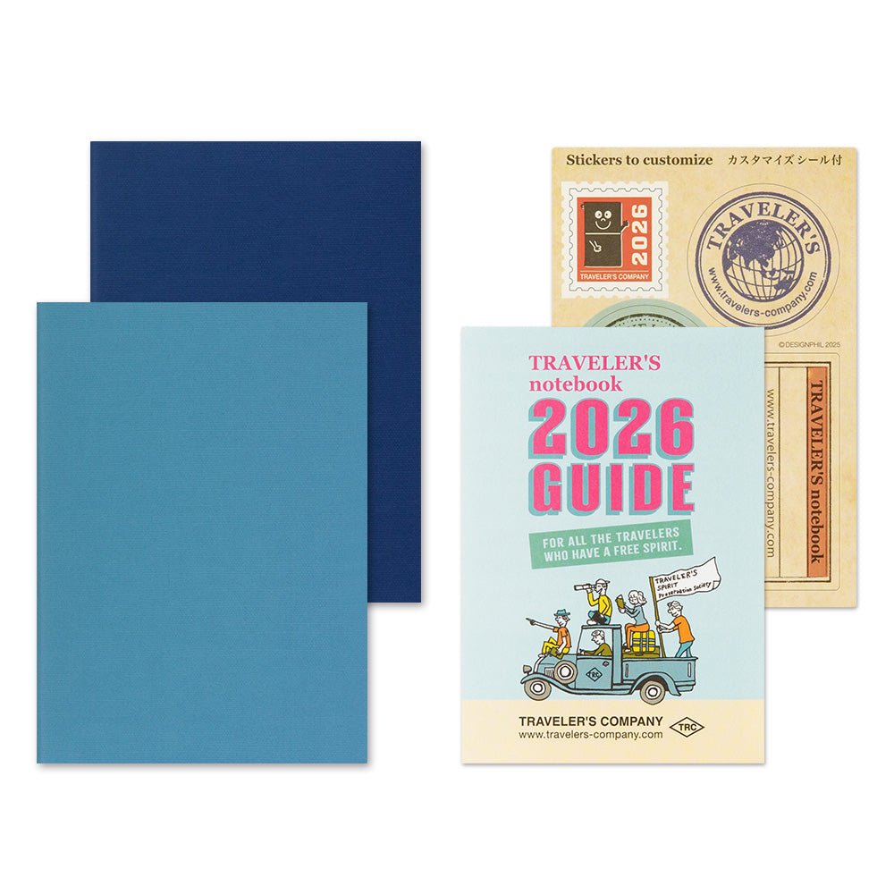 Blue TRAVELER'S notebook passport size 2026 planner with horizontal week over two pages layout showing the two 28 week inserts and the TRAVELER'S notebook 2026 guide and sticker set