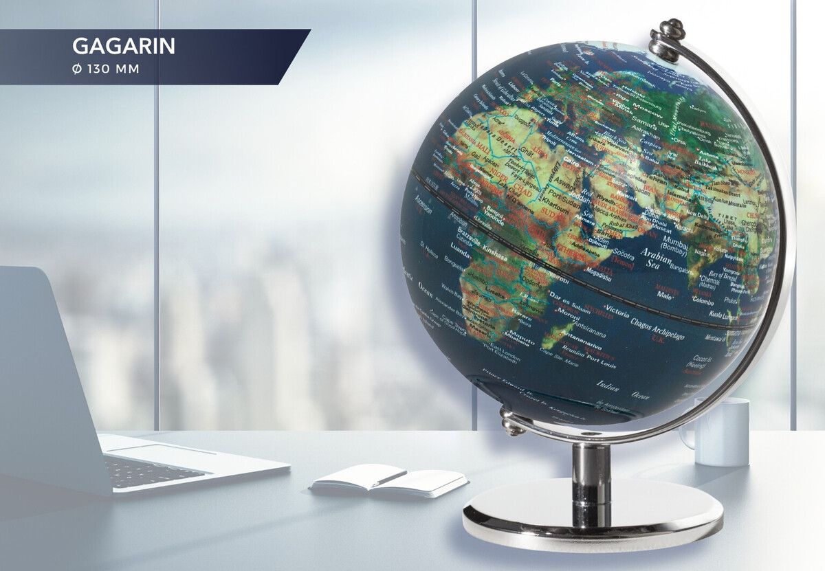 Multi-color Troika 5 inch globe with a laptop and paper on a blurred background 